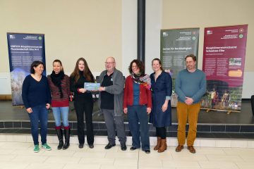 Sieben Personen nehmen im Gymnasium Boizenburg die Plakette zur Biosphärenschule entgegen.